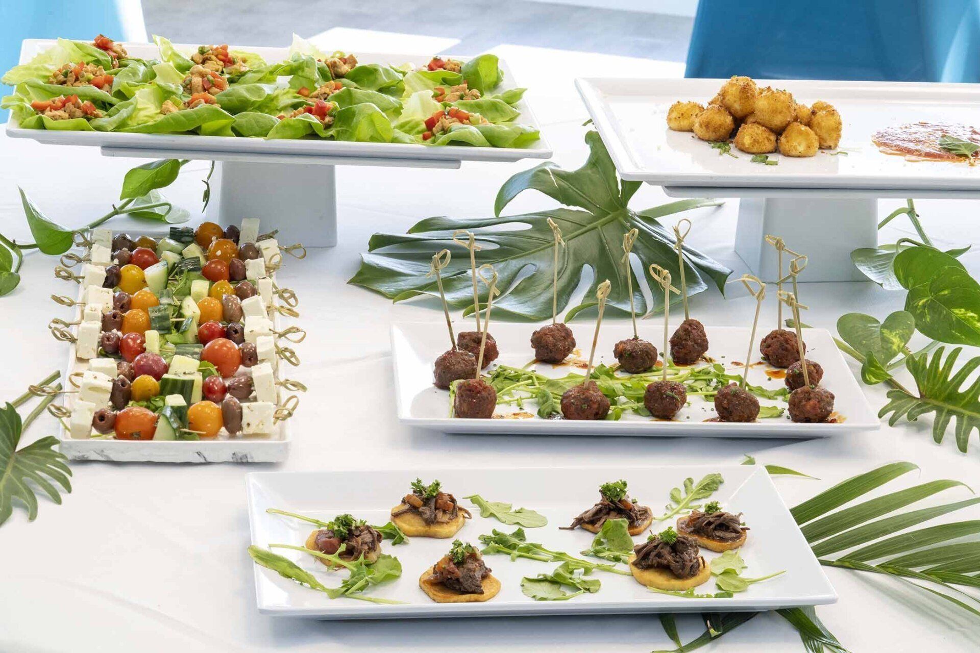 A table topped with plates of food including salads and appetizers