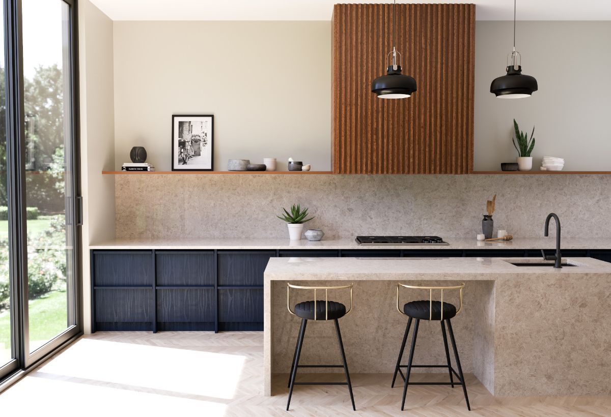 A kitchen with a large natural stone island and two stools.
