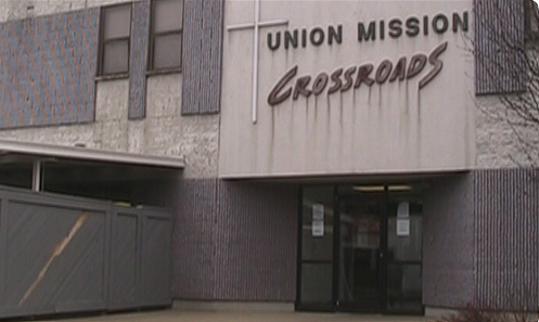 Entrance to Union Mission Crossroads building with glass doors and a gray exterior.