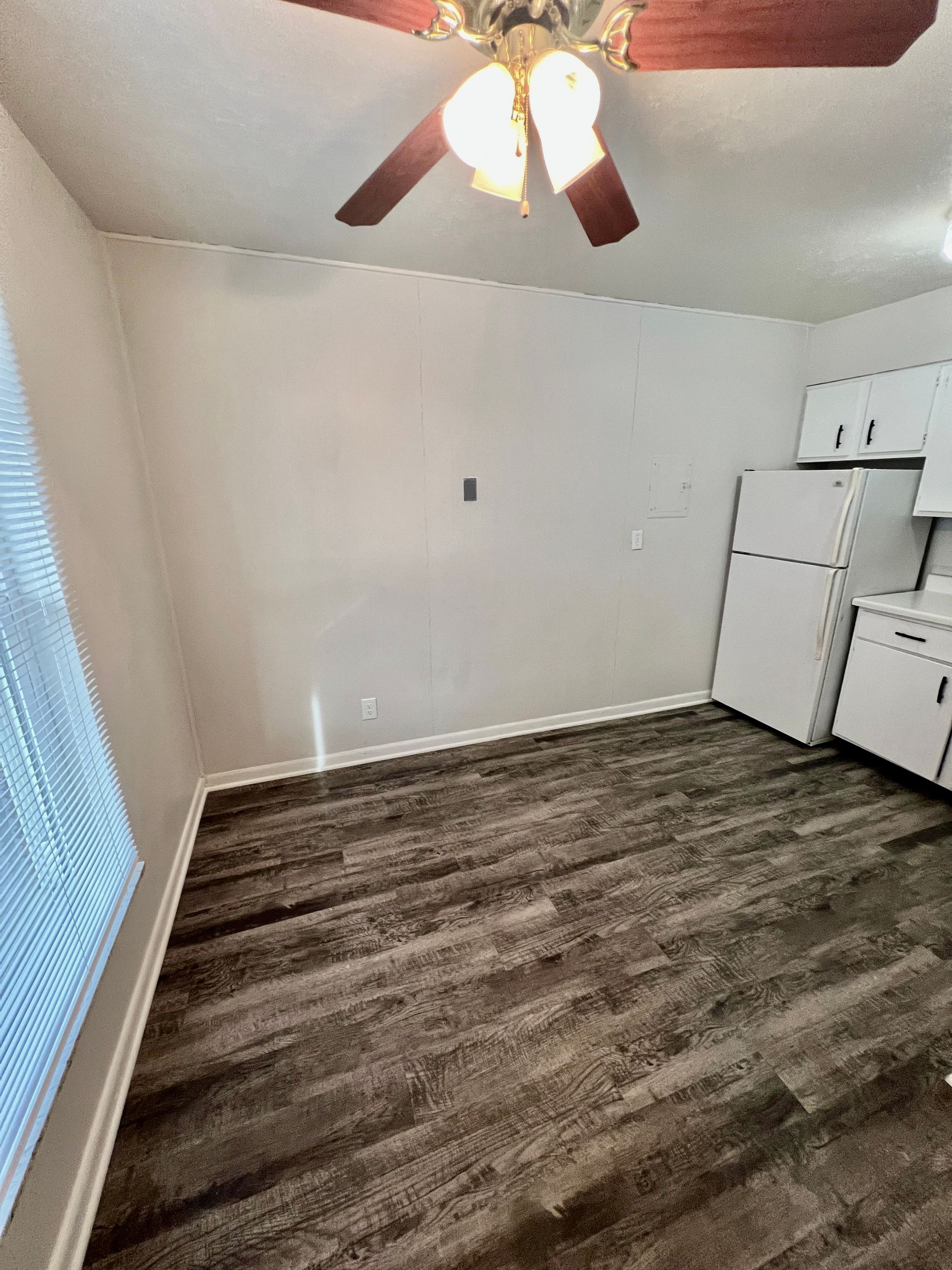 A kitchen with a ceiling fan and a refrigerator.