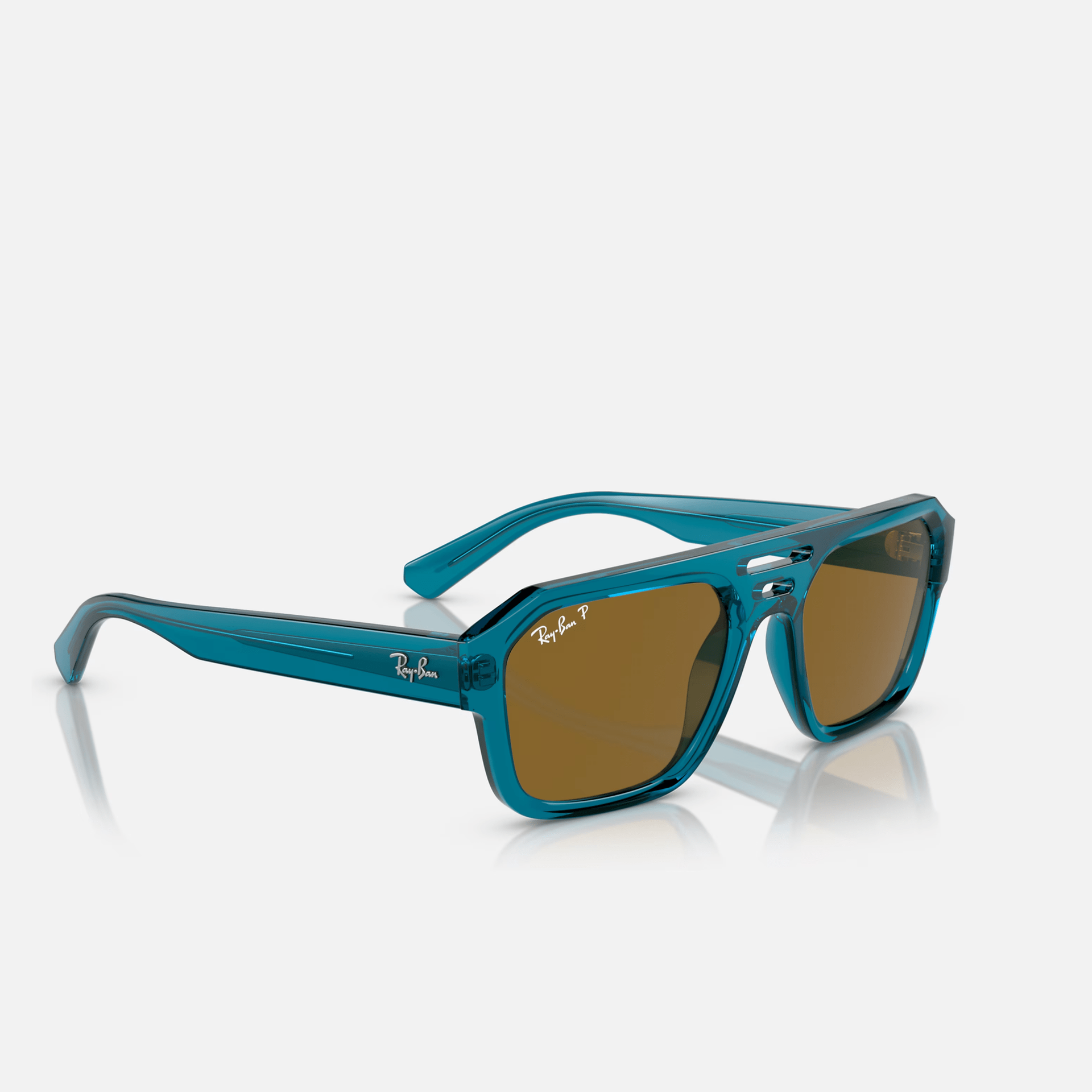 A pair of blue ray-ban sunglasses with brown lenses are sitting on a white surface.