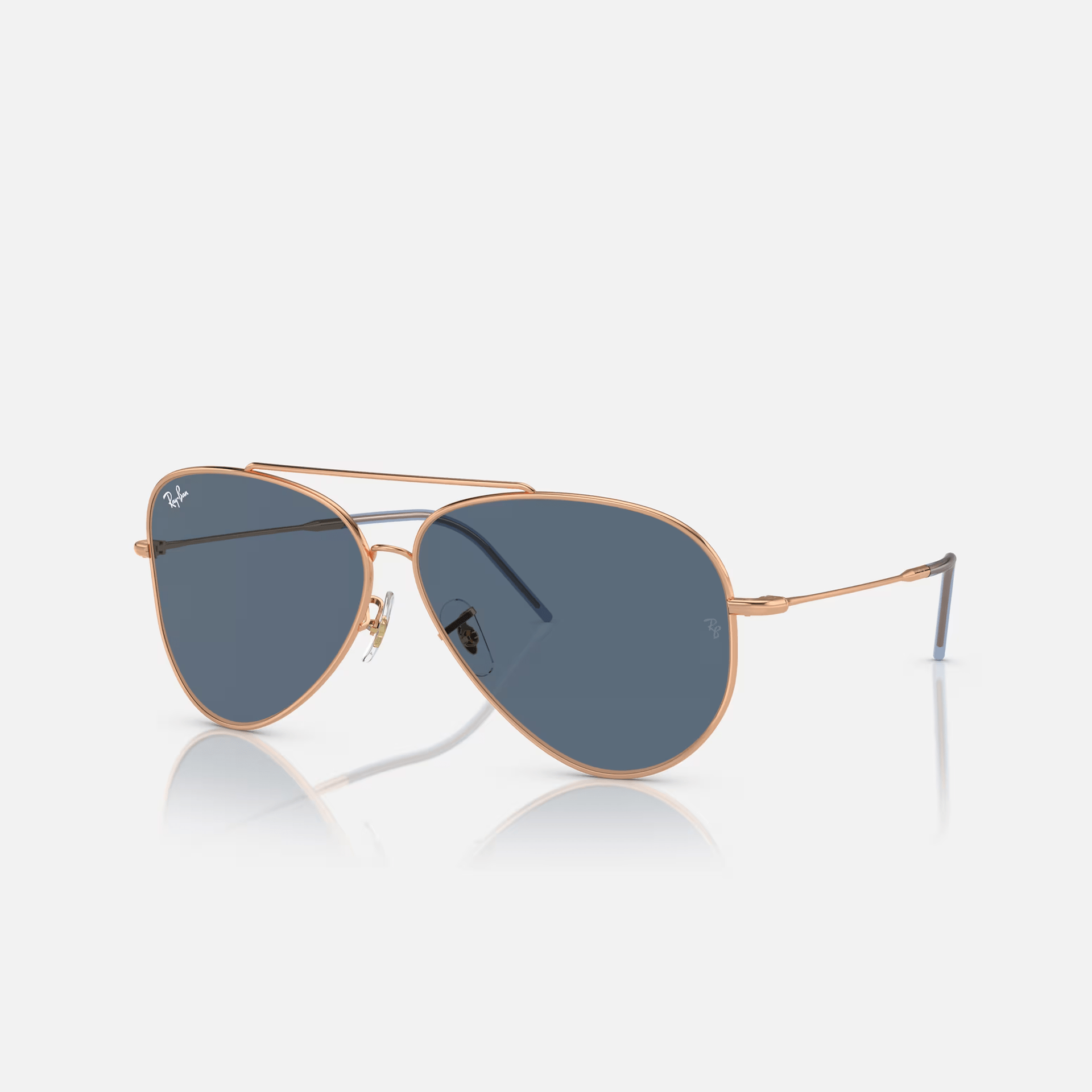 A pair of ray-ban aviator sunglasses on a white surface.