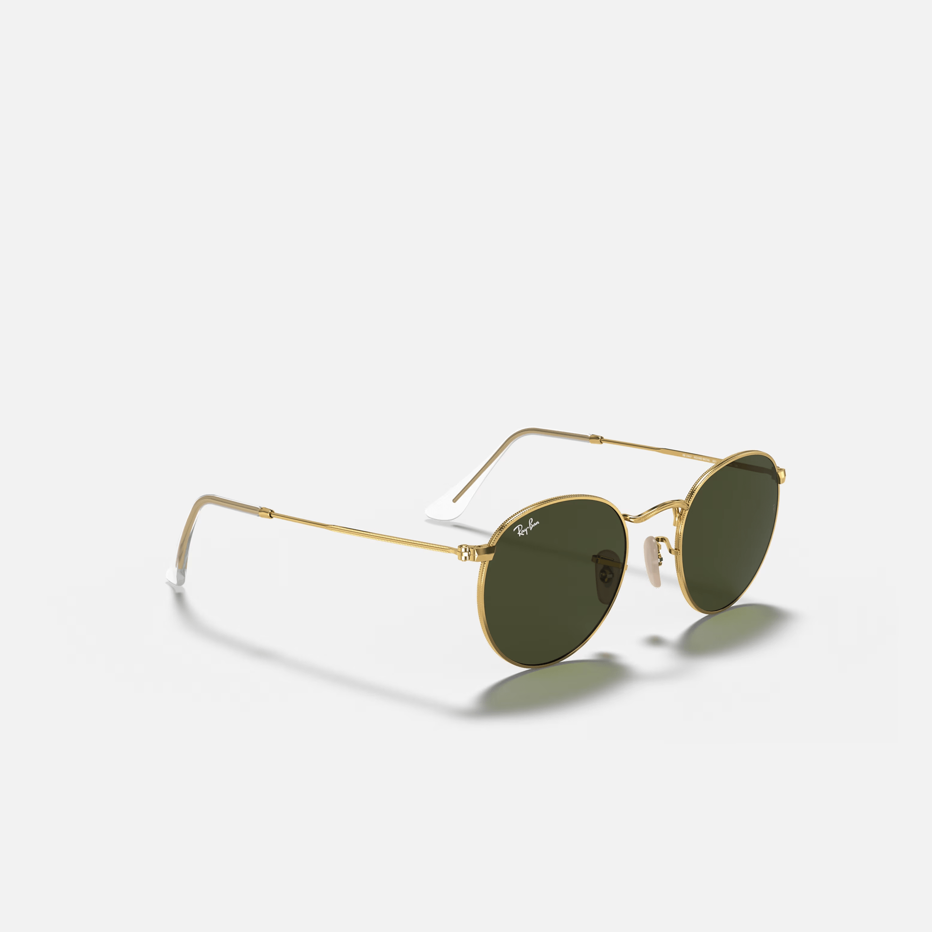 A pair of round sunglasses with a gold frame and green lenses on a white background.