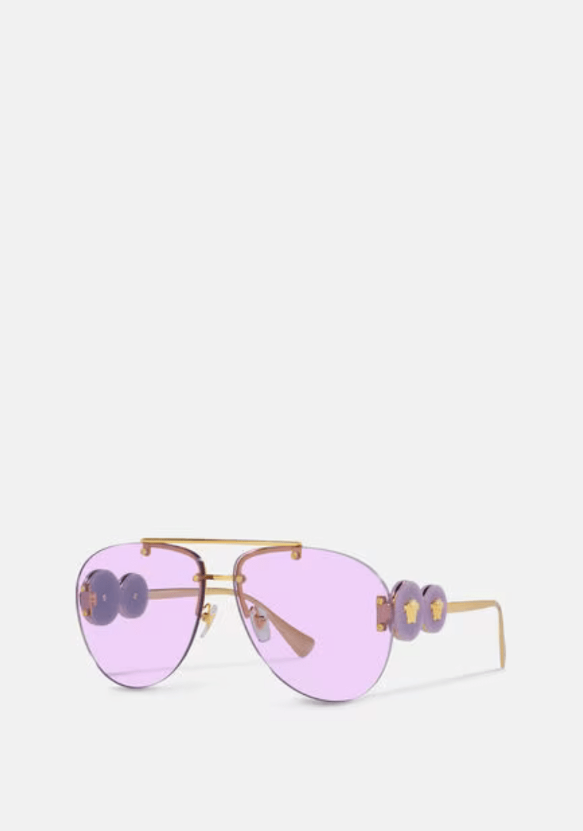 A pair of purple sunglasses with a gold frame on a white background.