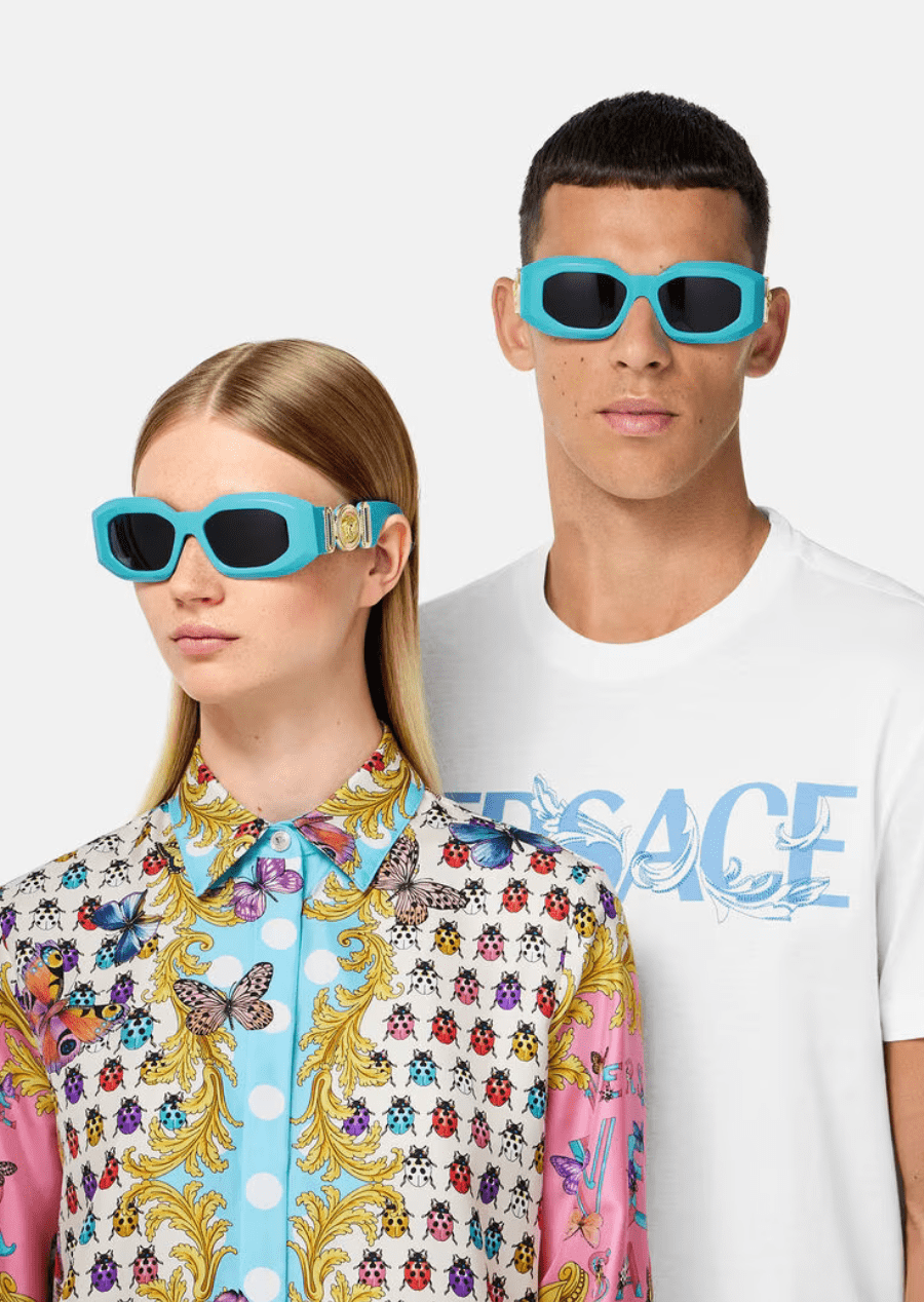 A man and a woman wearing sunglasses are standing next to each other.