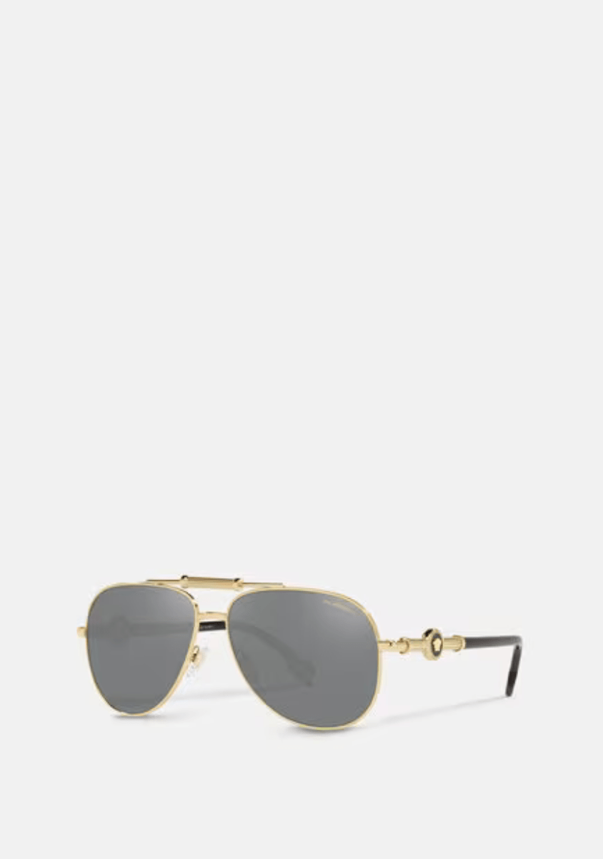 A pair of sunglasses with a gold frame and black lenses on a white background.
