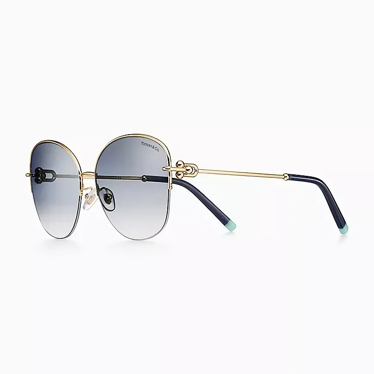 A pair of round sunglasses with blue lenses on a white background.