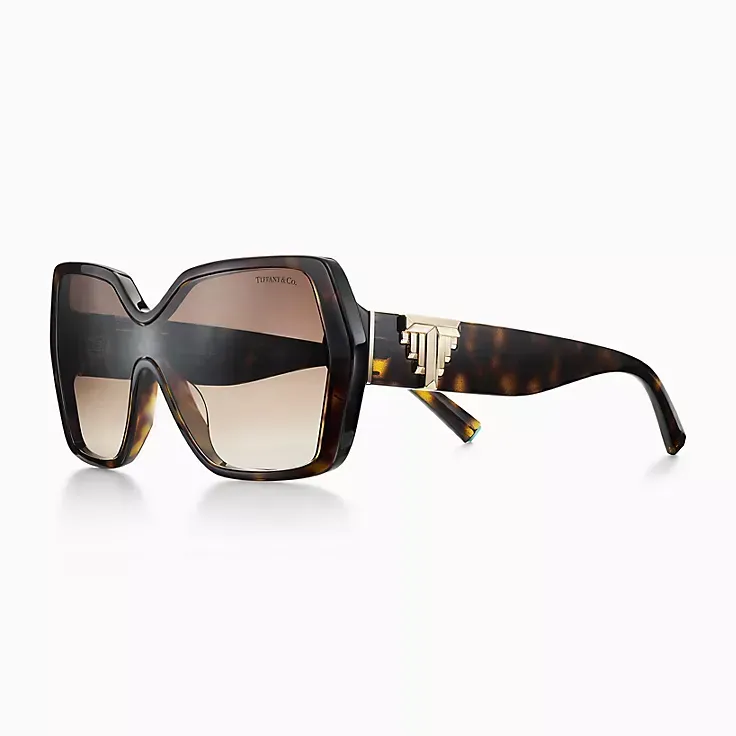 A pair of sunglasses with a black frame and brown lenses on a white background.