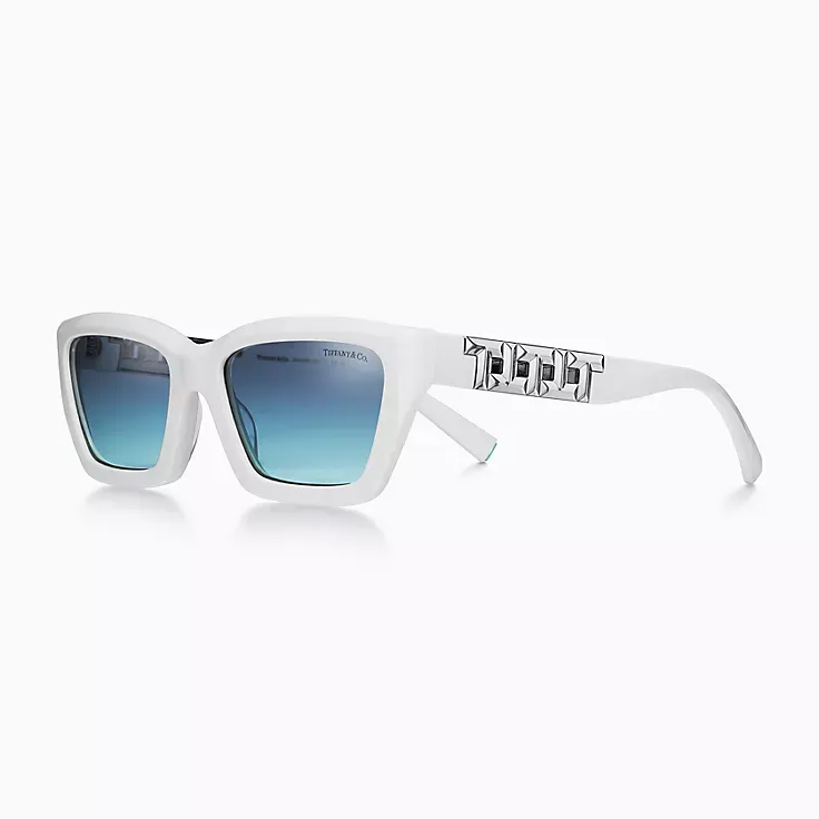A pair of white sunglasses with blue lenses on a white background.