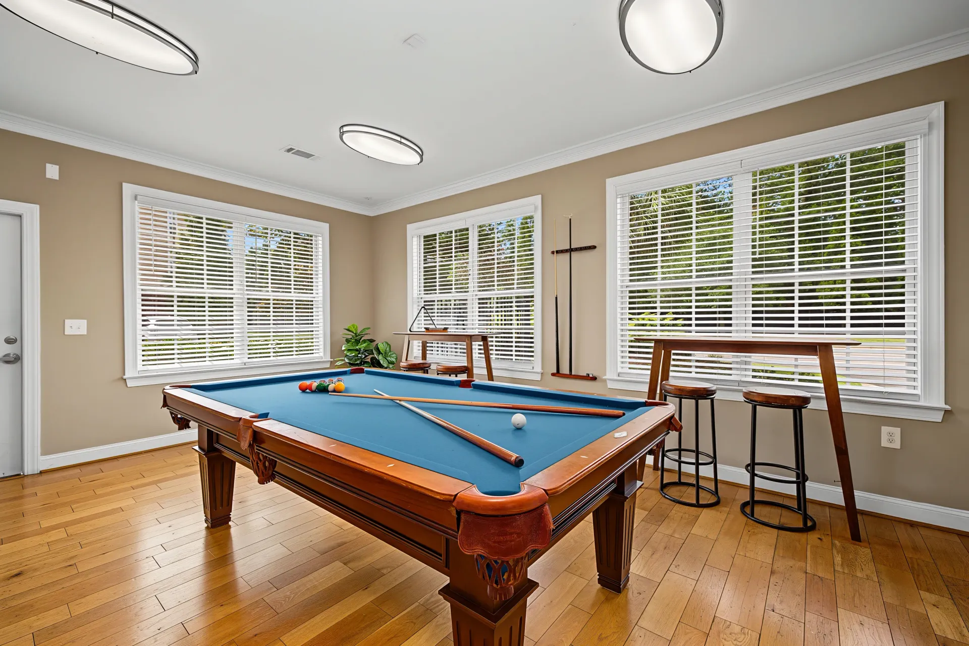 Billiard table and high-top bar tables in a common room.