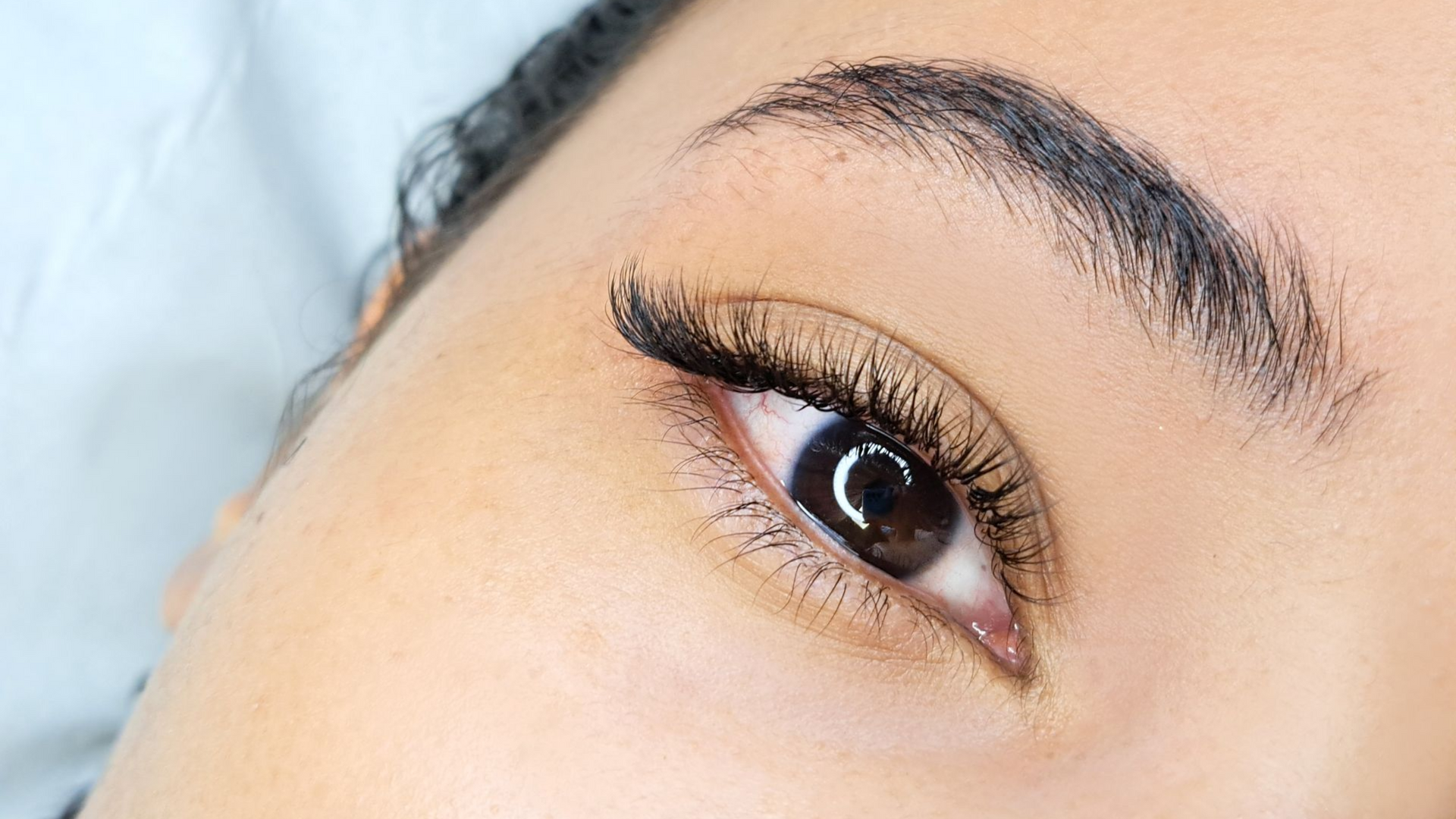Close-up of a human eye with winged black eyeliner and a softly arched eyebrow.