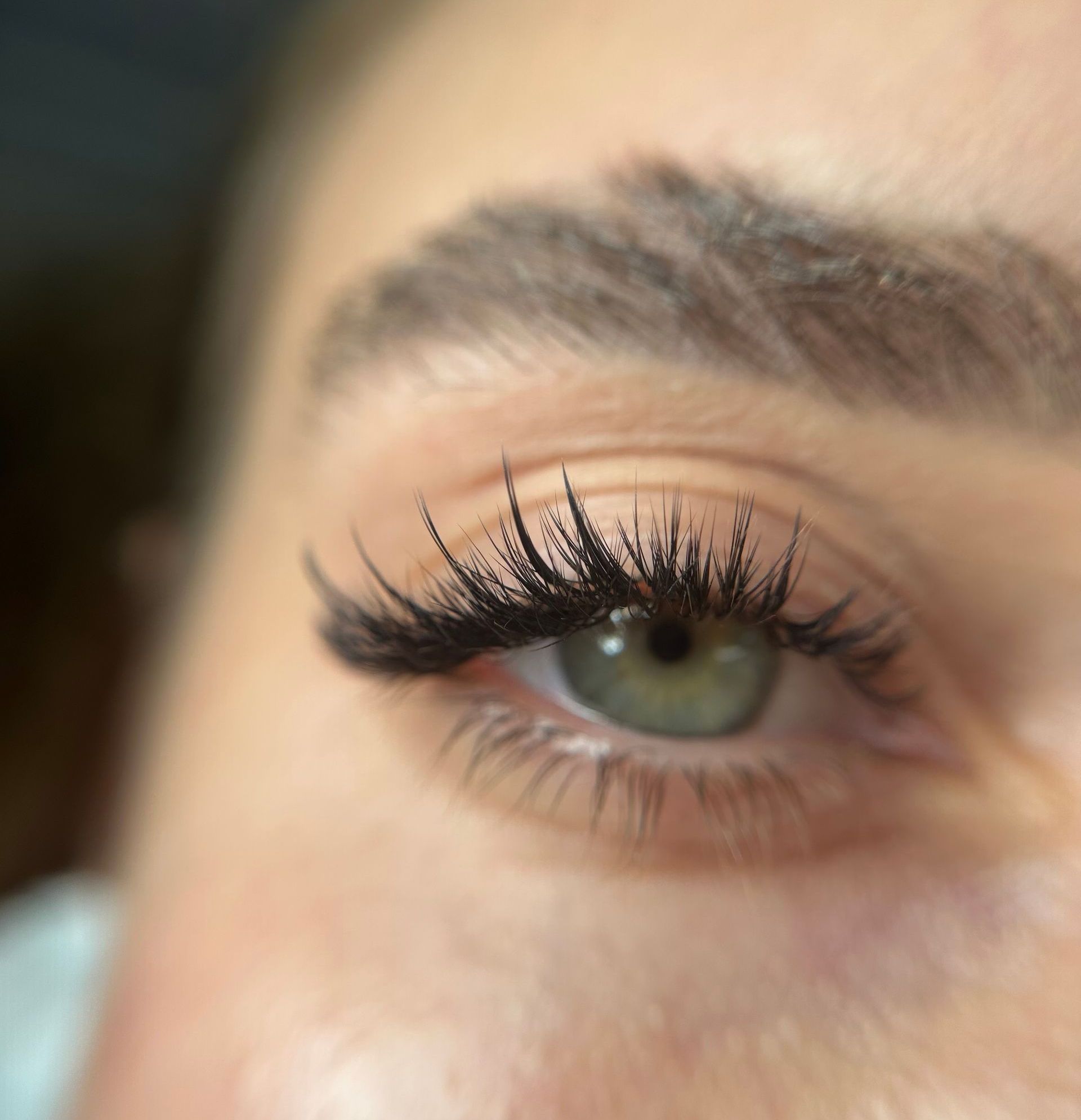 A close up of a woman 's eye with long eyelashes.
