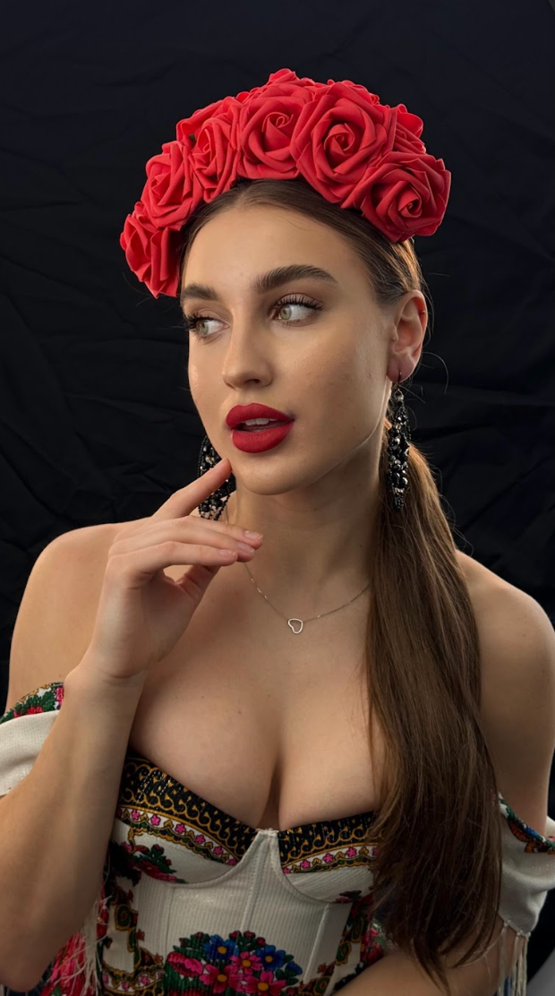 A woman is wearing a red flower crown on her head.