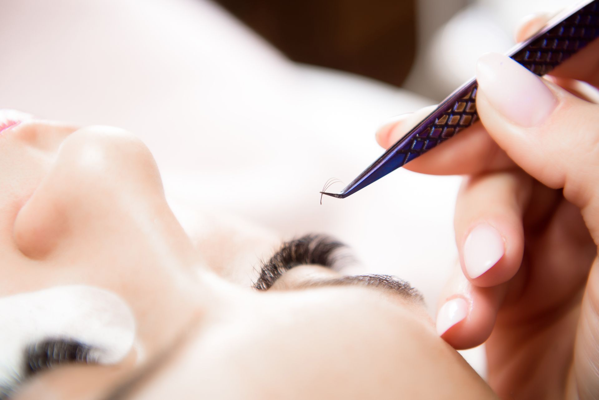 A woman is getting her eyelashes done at a beauty salon.