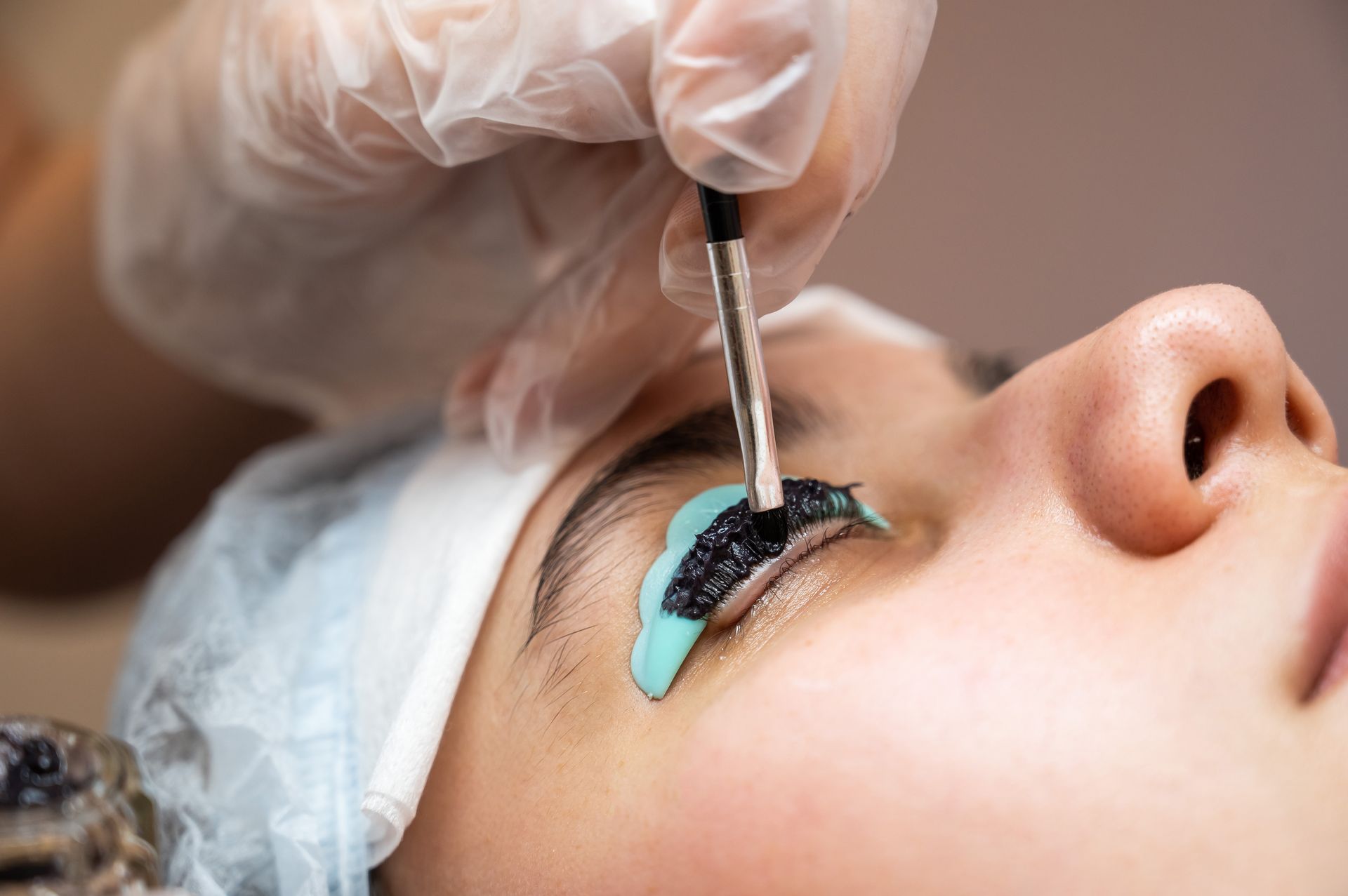 A woman is getting her eyelashes done at a beauty salon.
