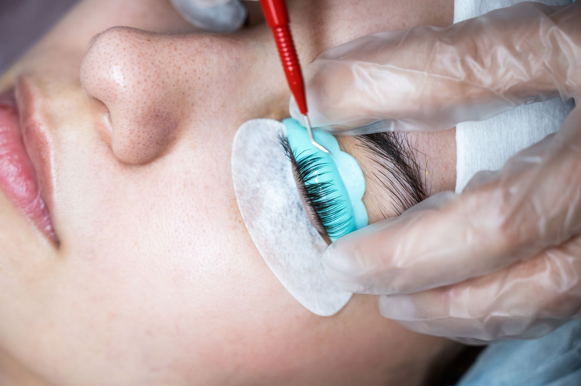 A woman is getting her eyelashes done at a beauty salon.