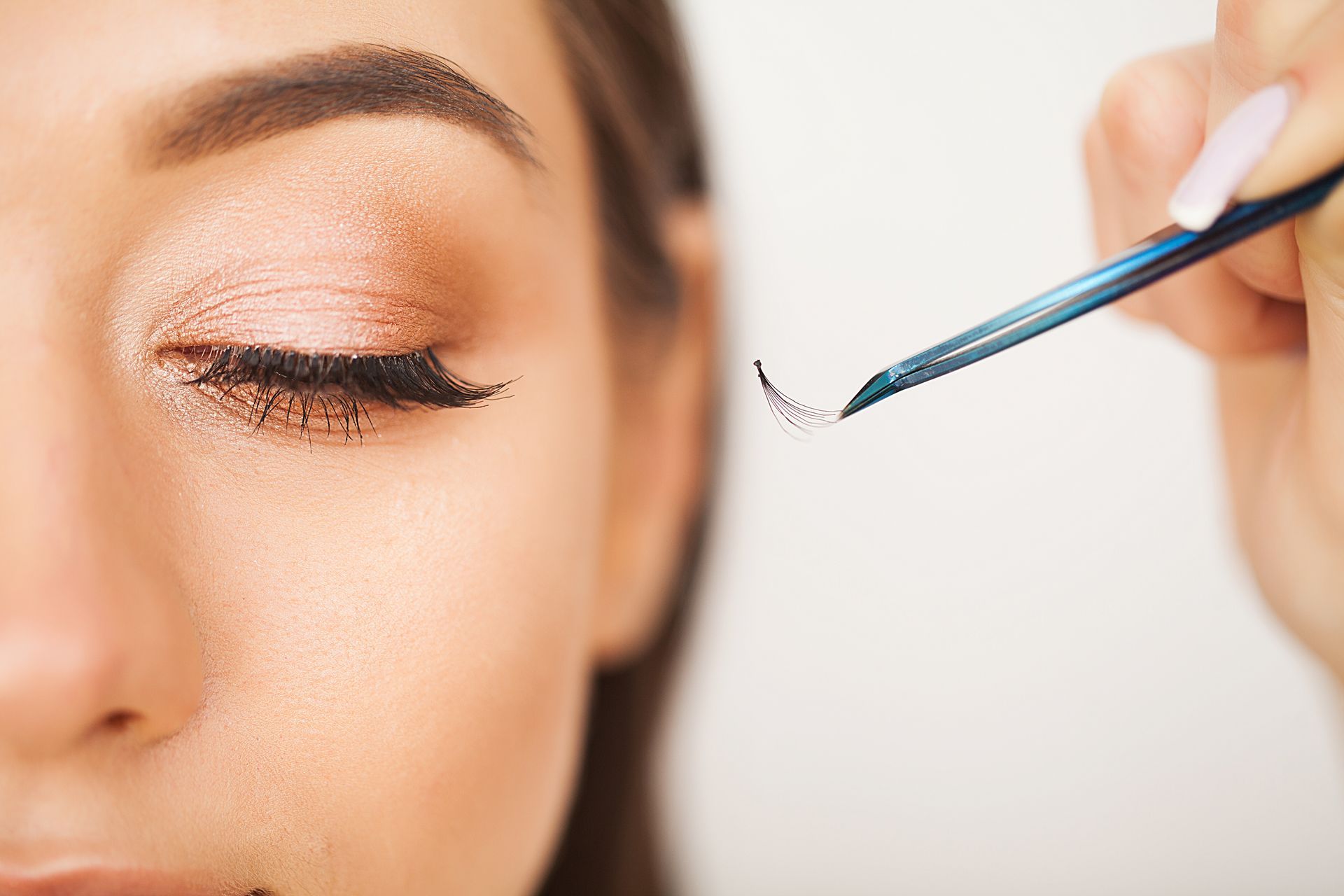 A woman is getting her eyelashes done at a beauty salon.