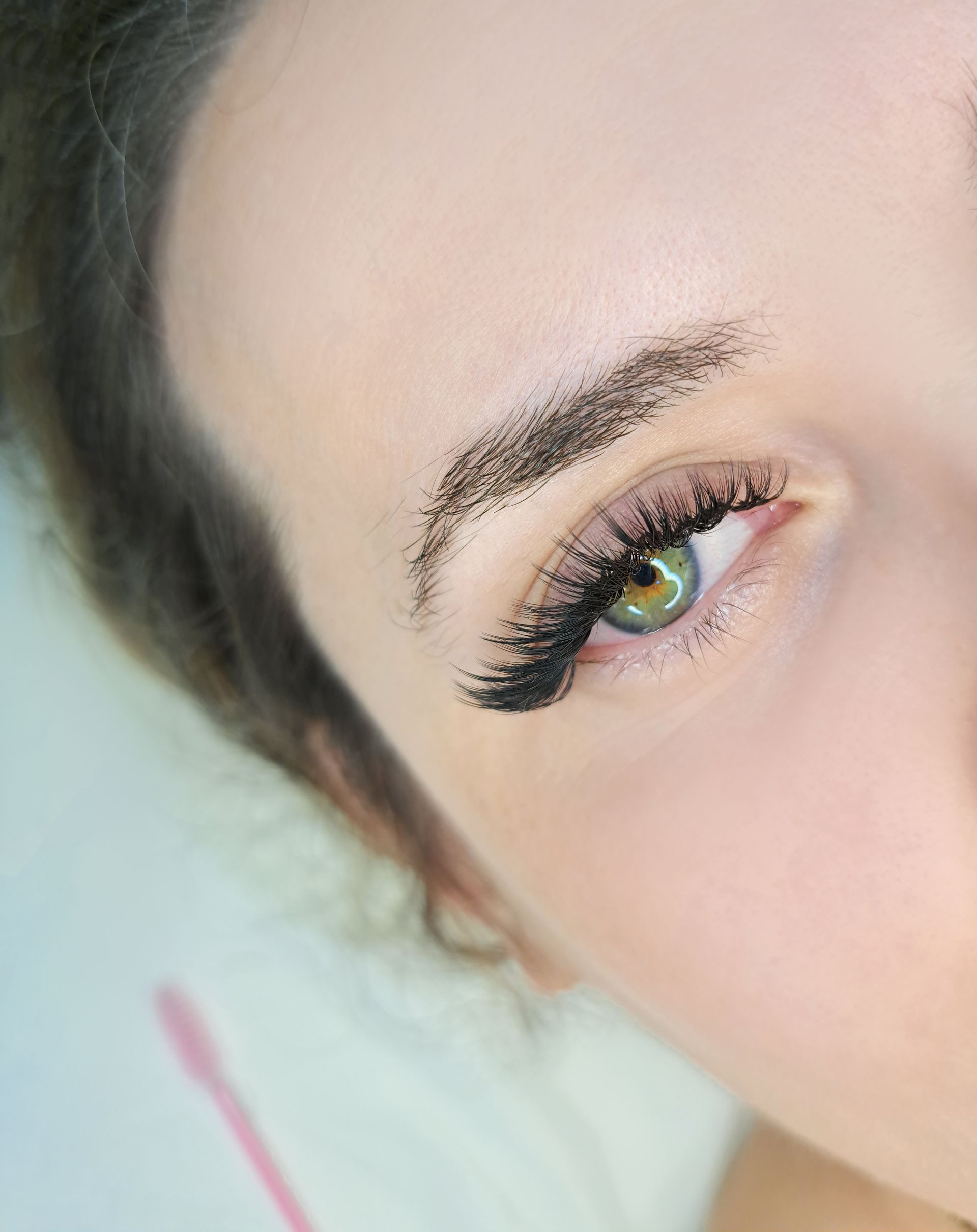 A close up of a woman 's eye with long eyelashes.