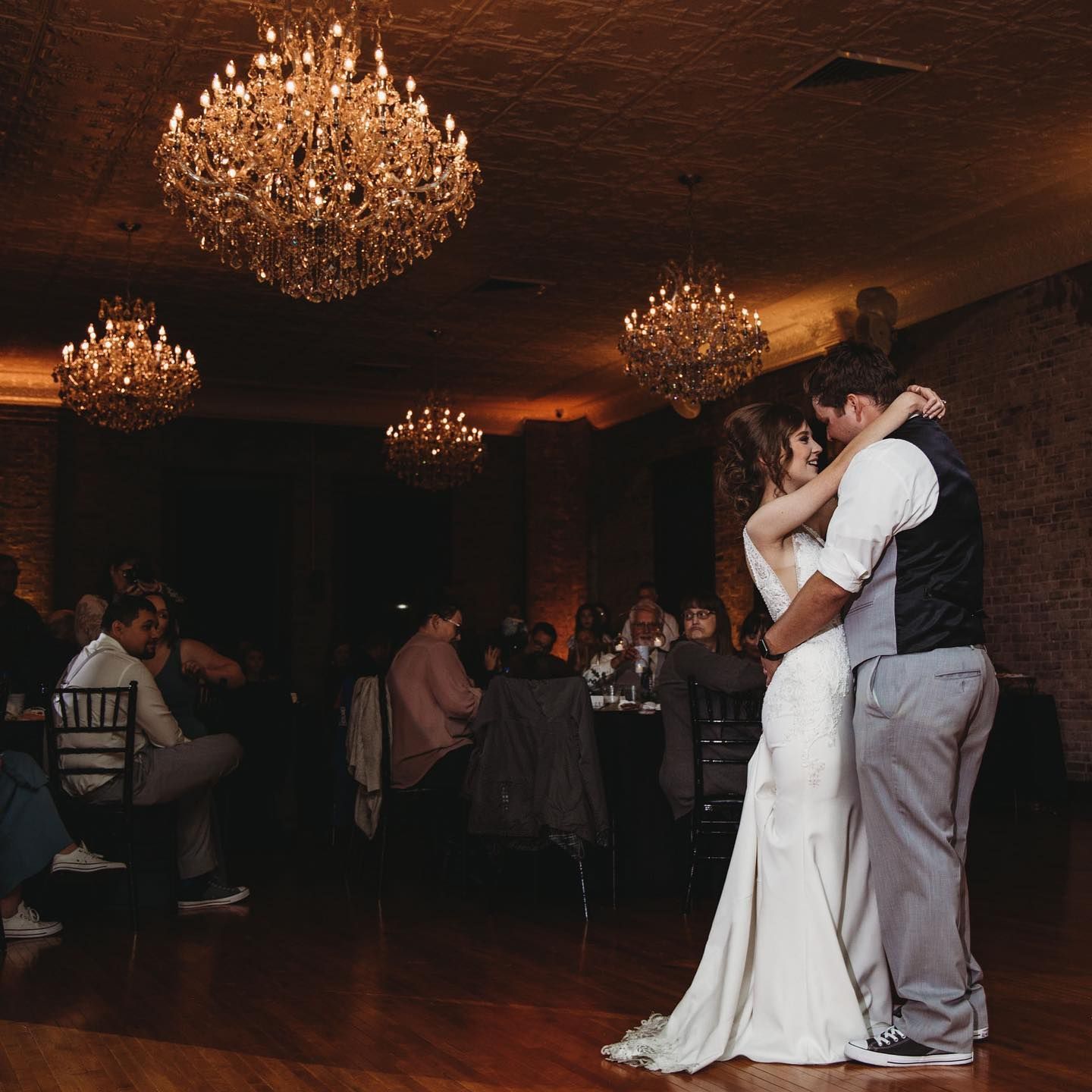 A bride and groom are dancing at their wedding reception