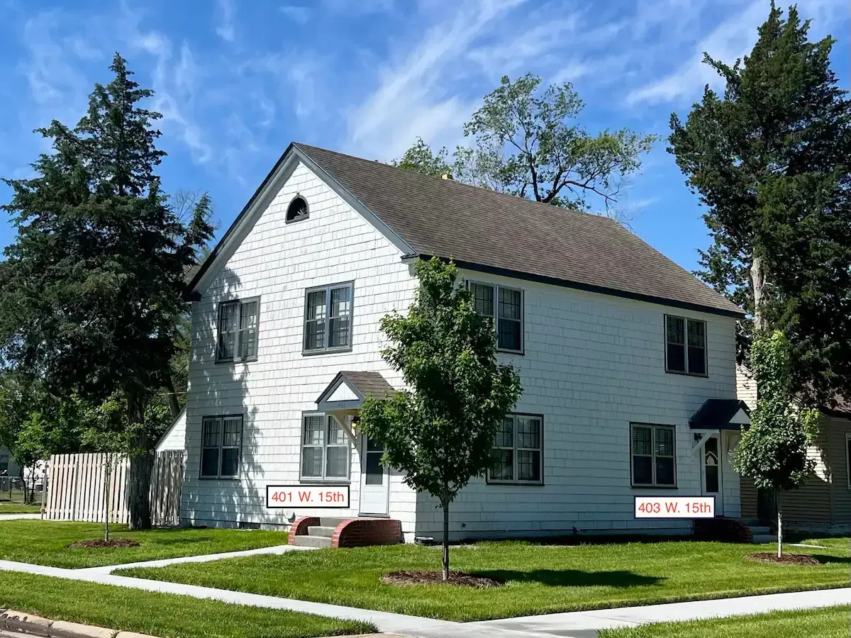 A white 2-story house with a gray roof.