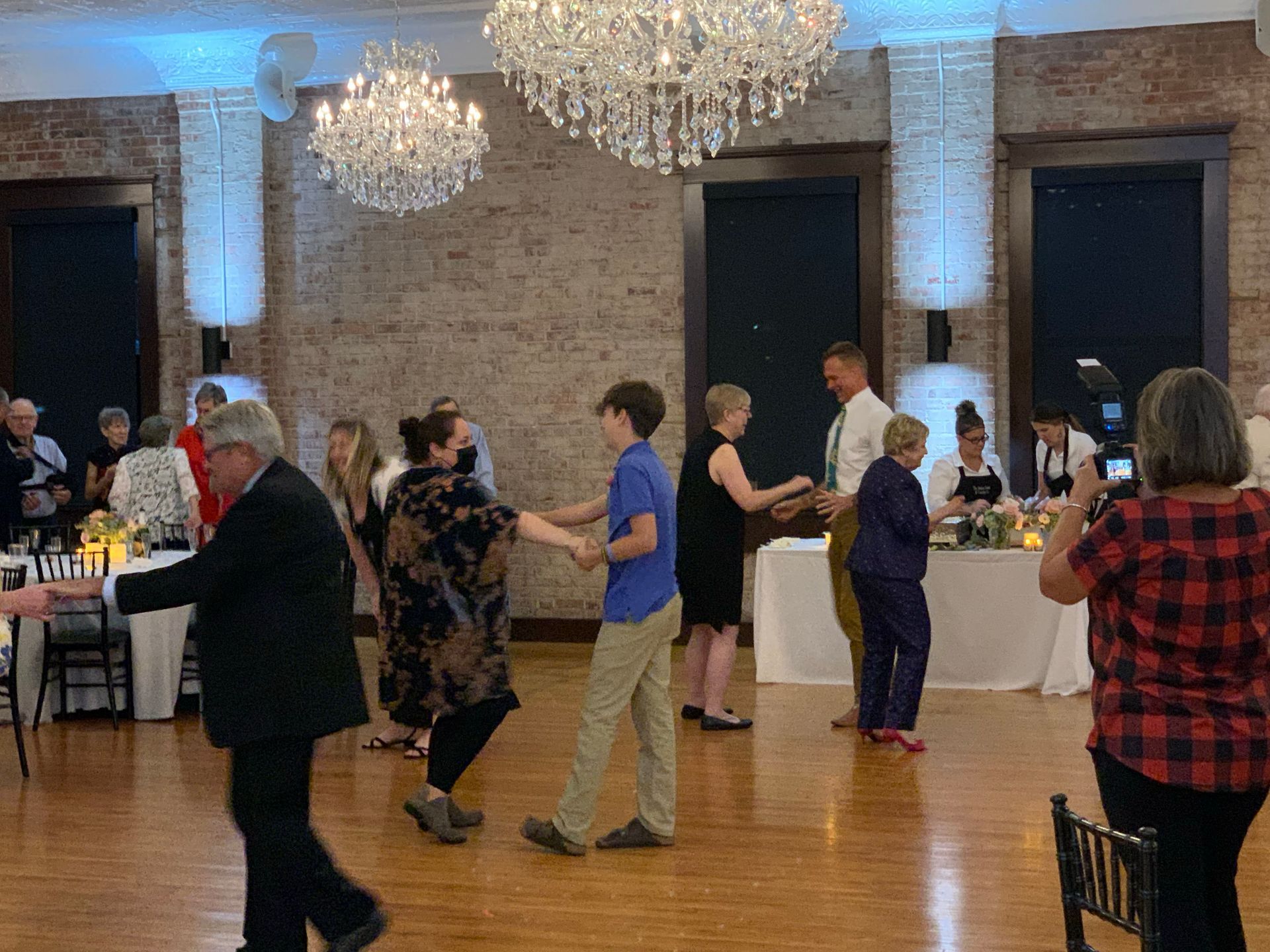 A group of people are dancing on a dance floor at a wedding reception.