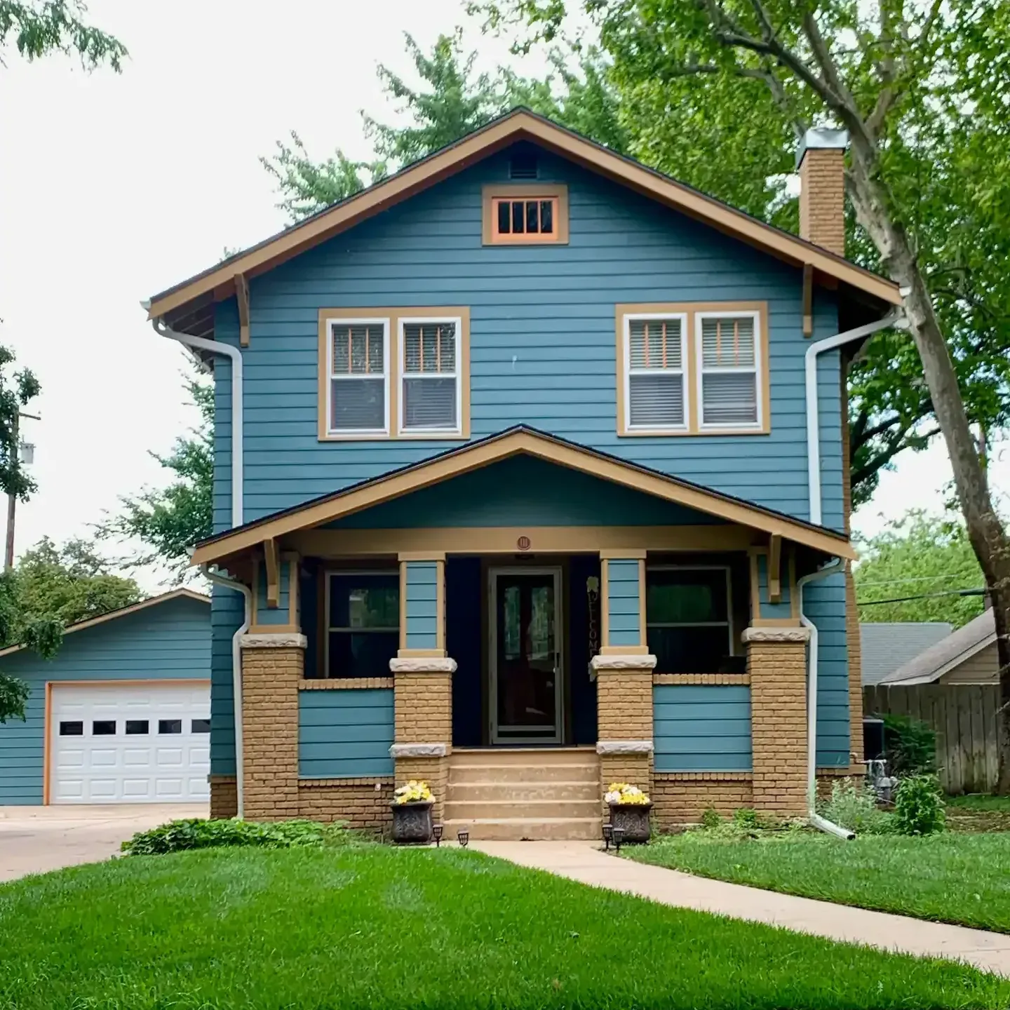 A blue house with a porch and a garage