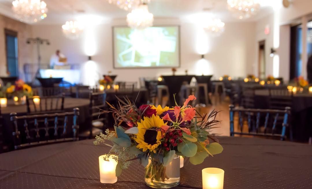A table with a vase of flowers and candles on it.