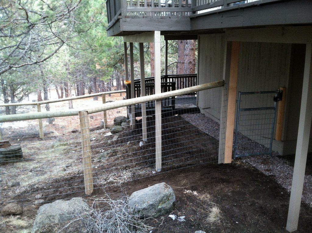 Wooden fence and deck supports on a hillside, creating a barrier.