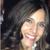 A woman with long dark hair is smiling for the camera.