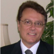A man in a suit and tie is smiling for the camera.