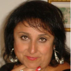 A close up of a woman 's face wearing earrings and a ring