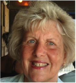 A woman with blonde hair and blue eyes is smiling for the camera.