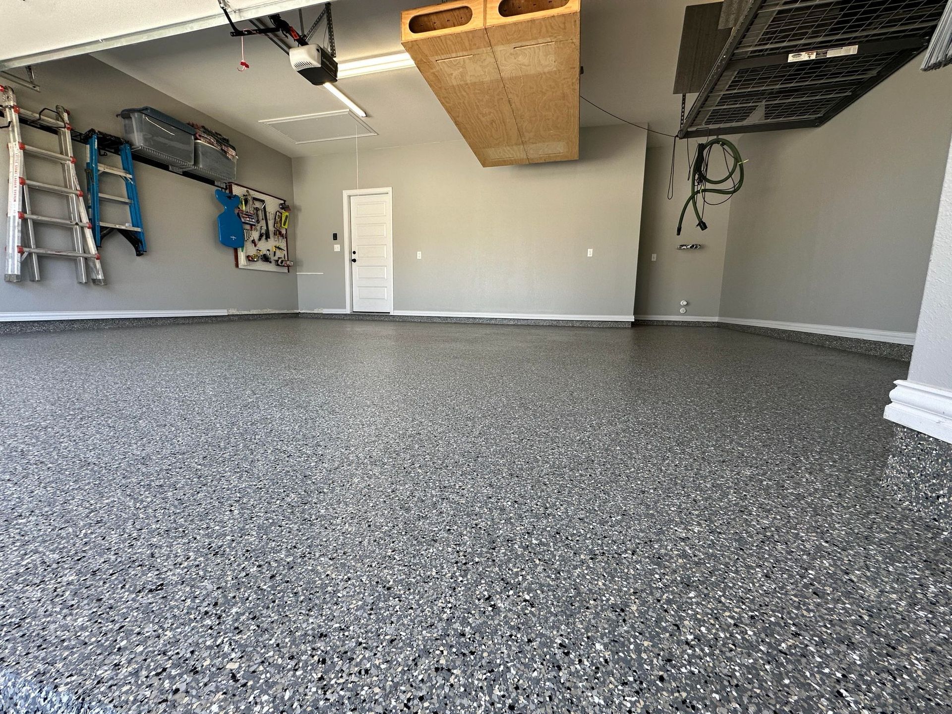 two men are working on a concrete floor in a room .