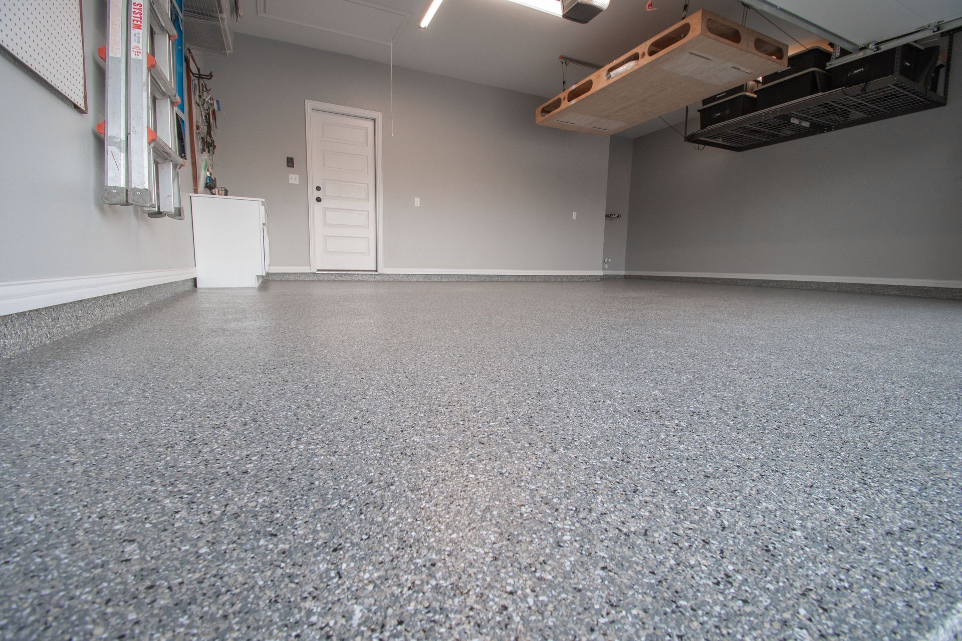 a garage with a gray floor and a white door