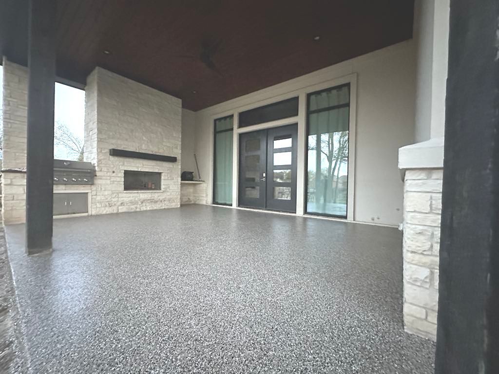a patio with a concrete floor and a fireplace .