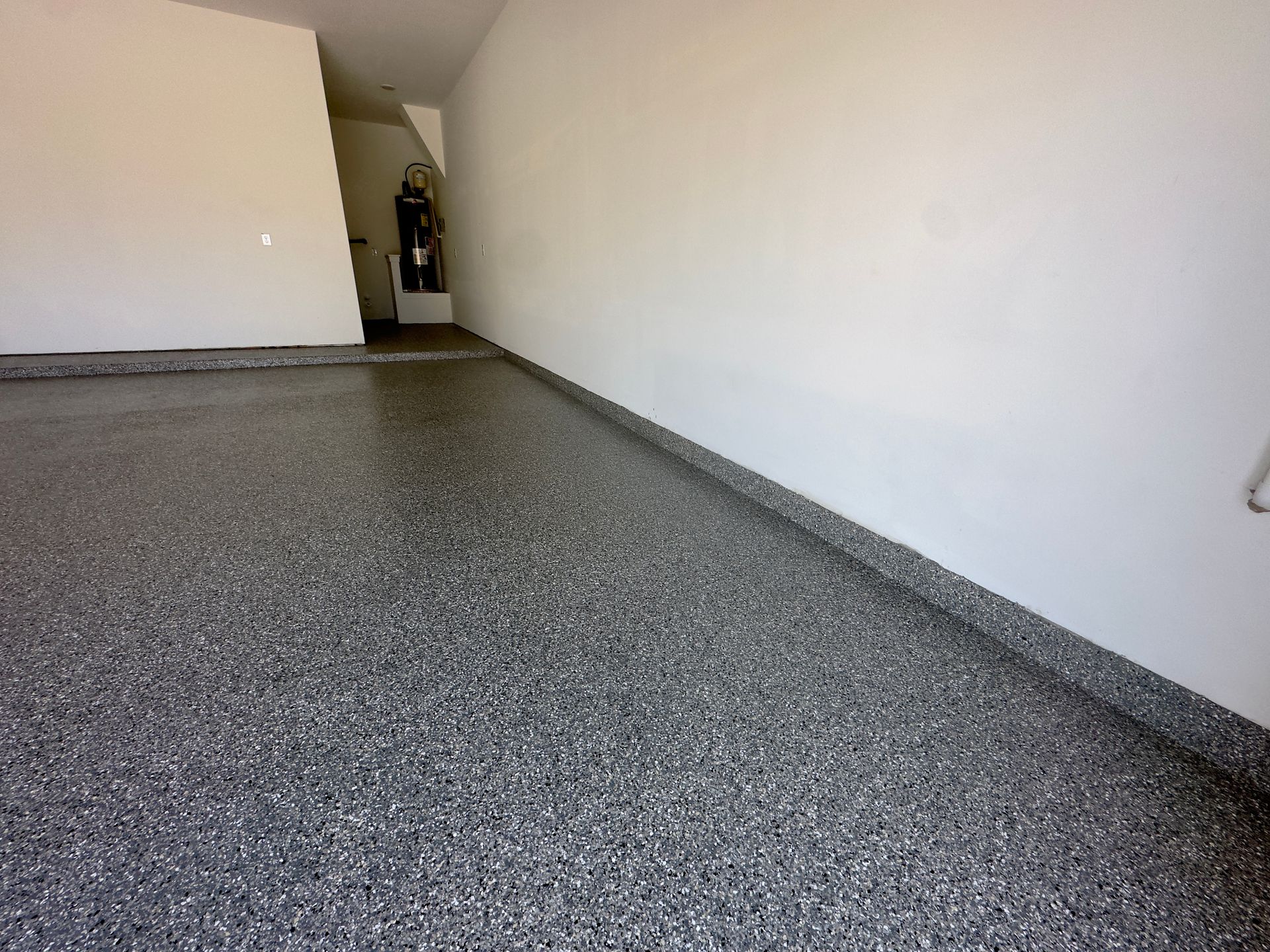 a garage with a gray epoxy floor and white walls
