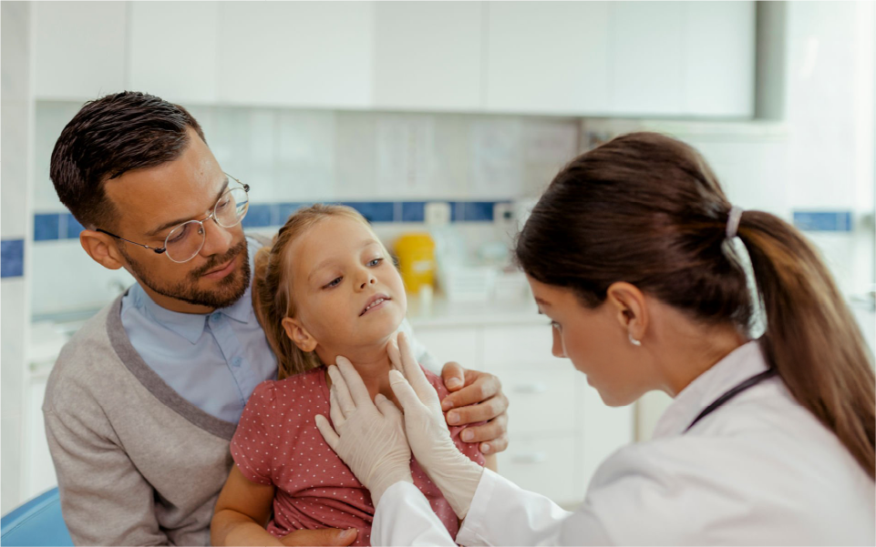 Doctor examining a crying baby while a parent holds them outdoors on a porch