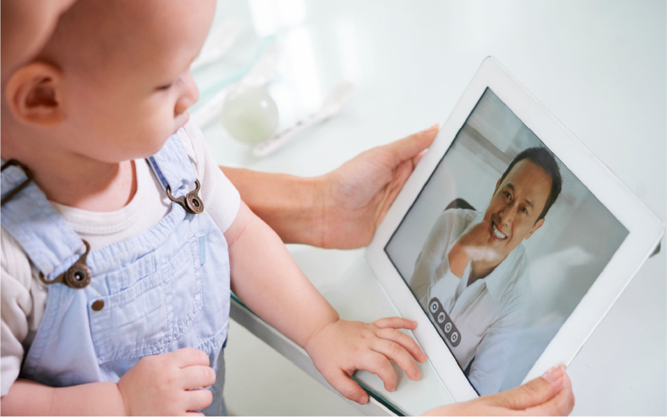 Healthcare worker in blue gloves checks a child’s arm while seated in a bright clinic.