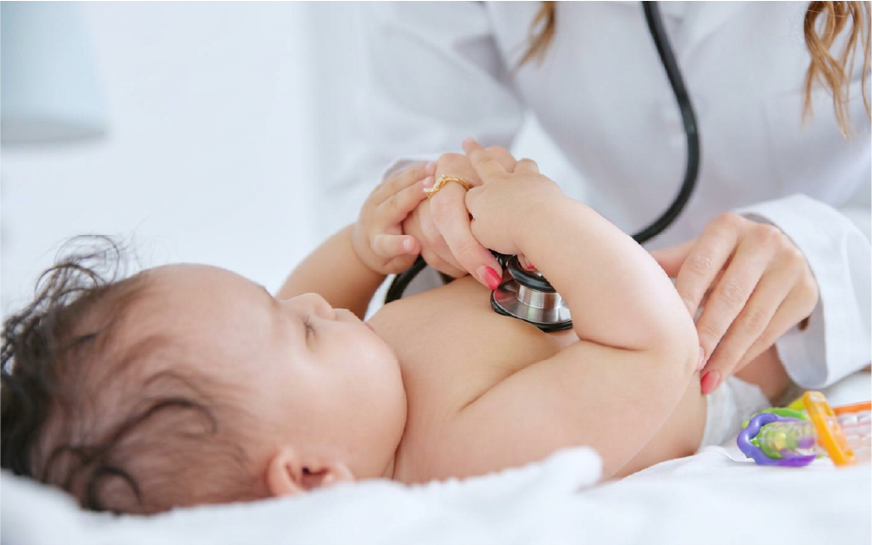 Baby being measured with a tape measure on the head by hands in a clinical setting
