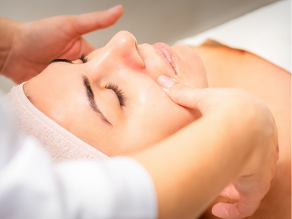 Person receiving a spa massage on a treatment table, surrounded by soft candlelight and towels