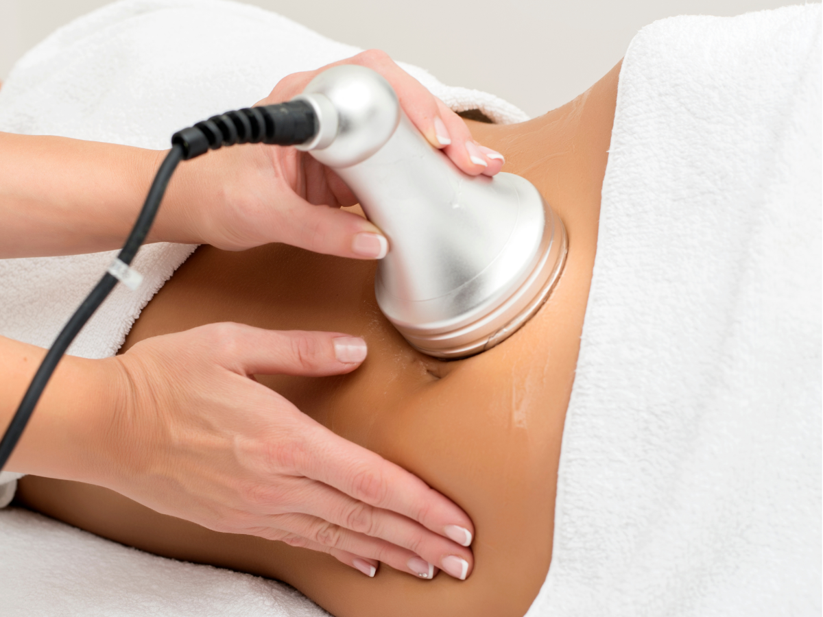Massage therapist pressing hands into a client’s bare back during a spa treatment