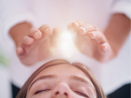 Person receiving a spa massage on a treatment table, surrounded by soft candlelight and towels