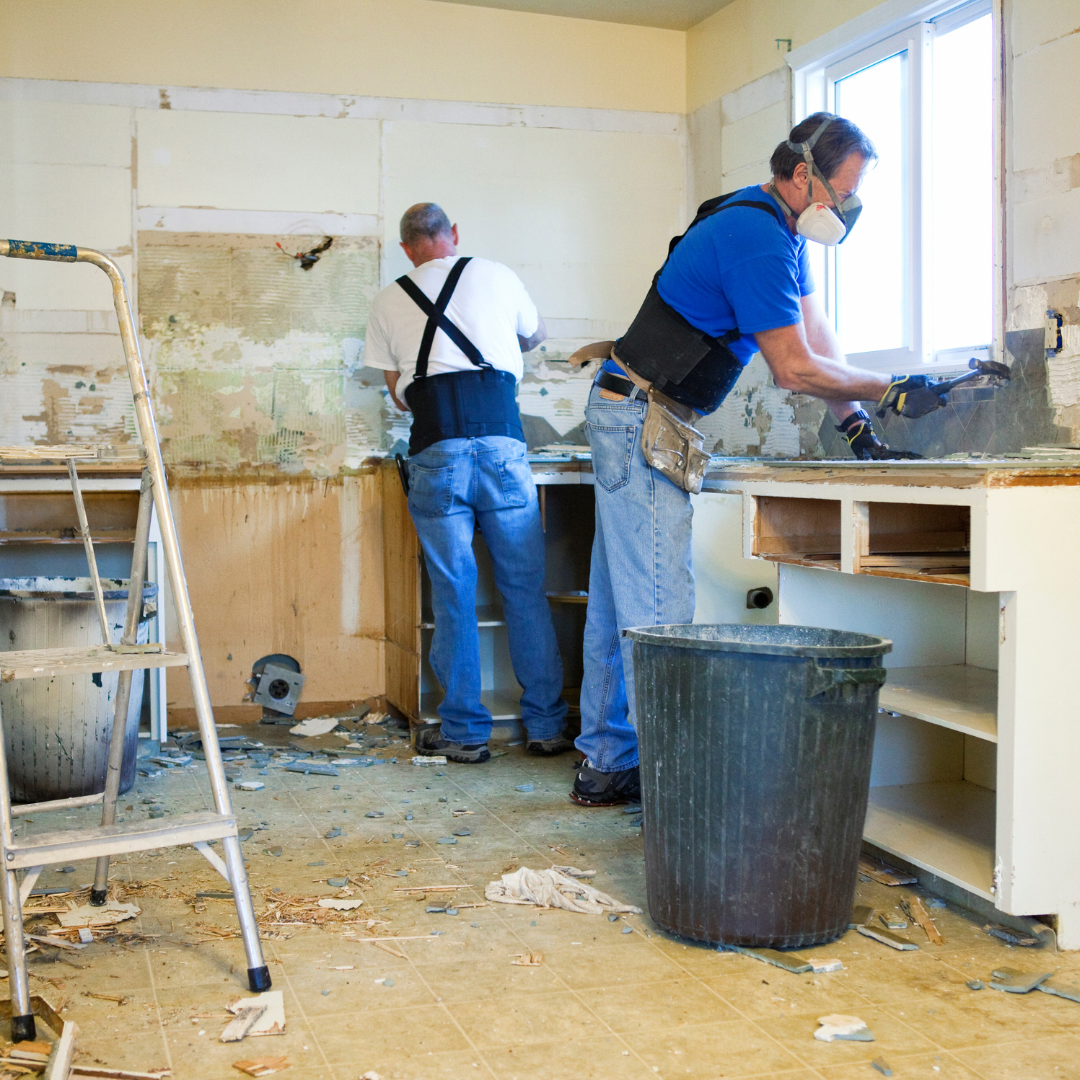 Two men wearing masks are working in a kitchen