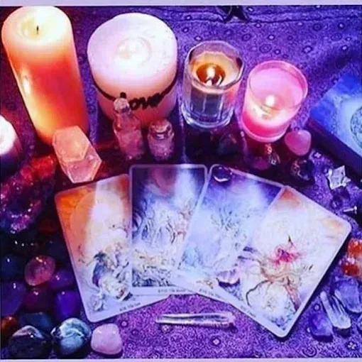A deck of tarot cards is sitting on a table next to candles. A deck of tarot cards is sitting on a table next to candles.