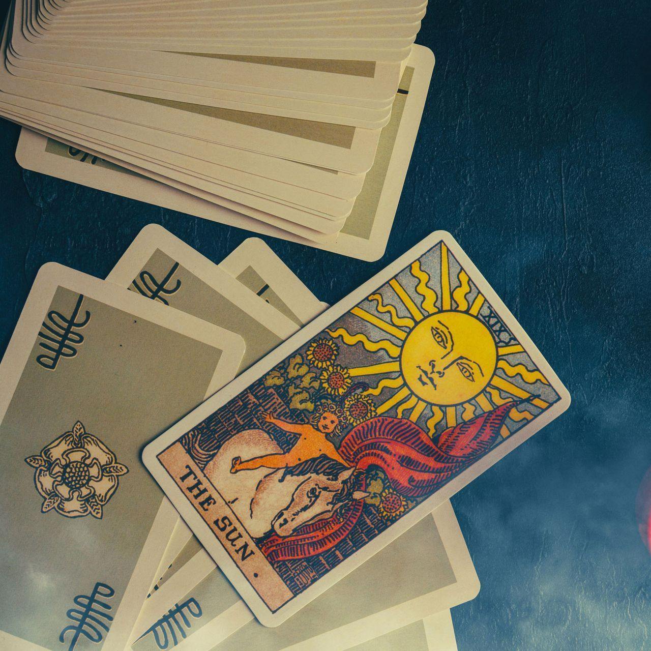 The sun tarot card is surrounded by other tarot cards The sun tarot card is surrounded by other tarot cards