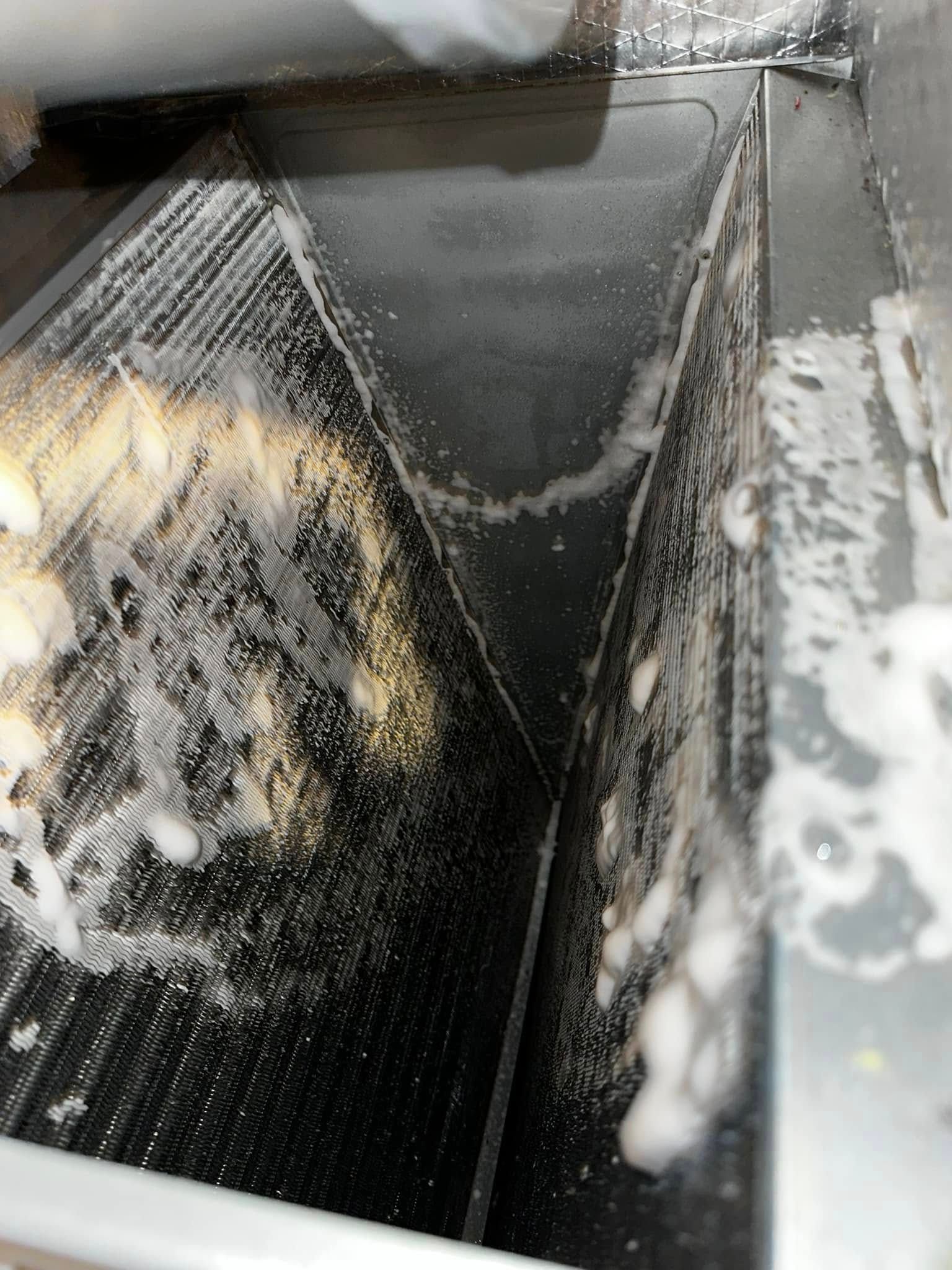 Dirty sink drain with white soap residue and a dark, wet basin