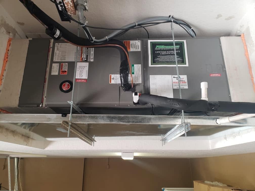 HVAC air handler in ceiling with exposed wiring, ducts, and insulated vent panels