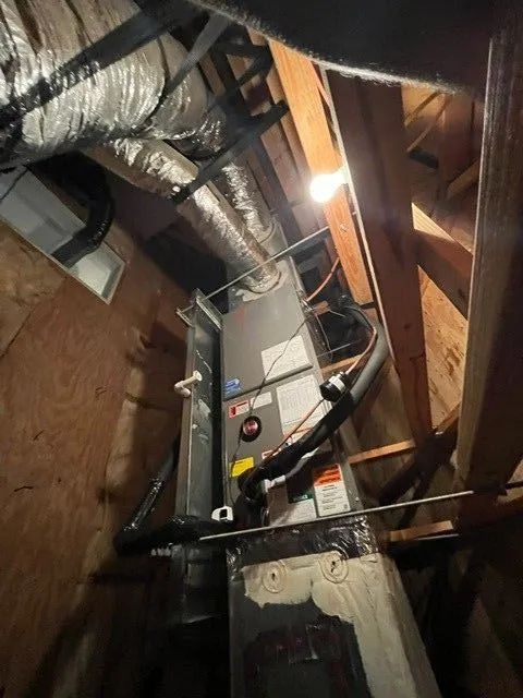 Basement utility area with HVAC equipment, exposed ductwork, and wooden framing