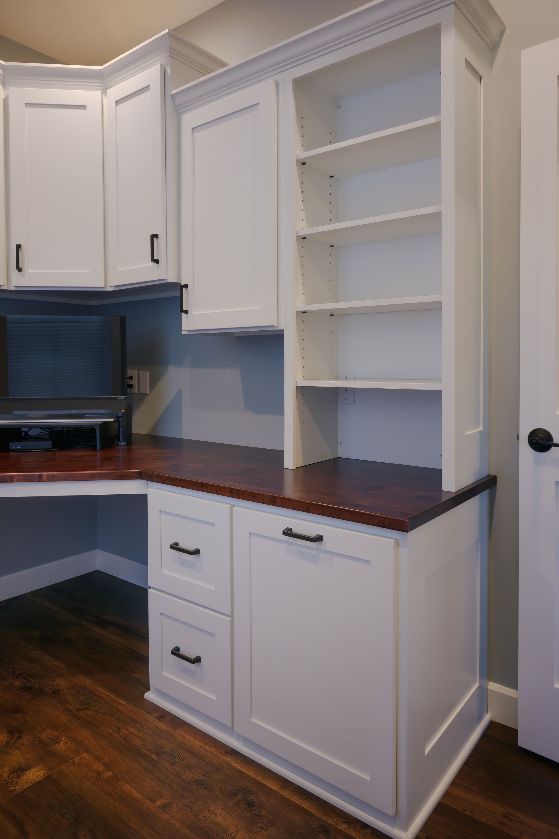 Custom white painted wood office with adjustable shelves and stained wood top.