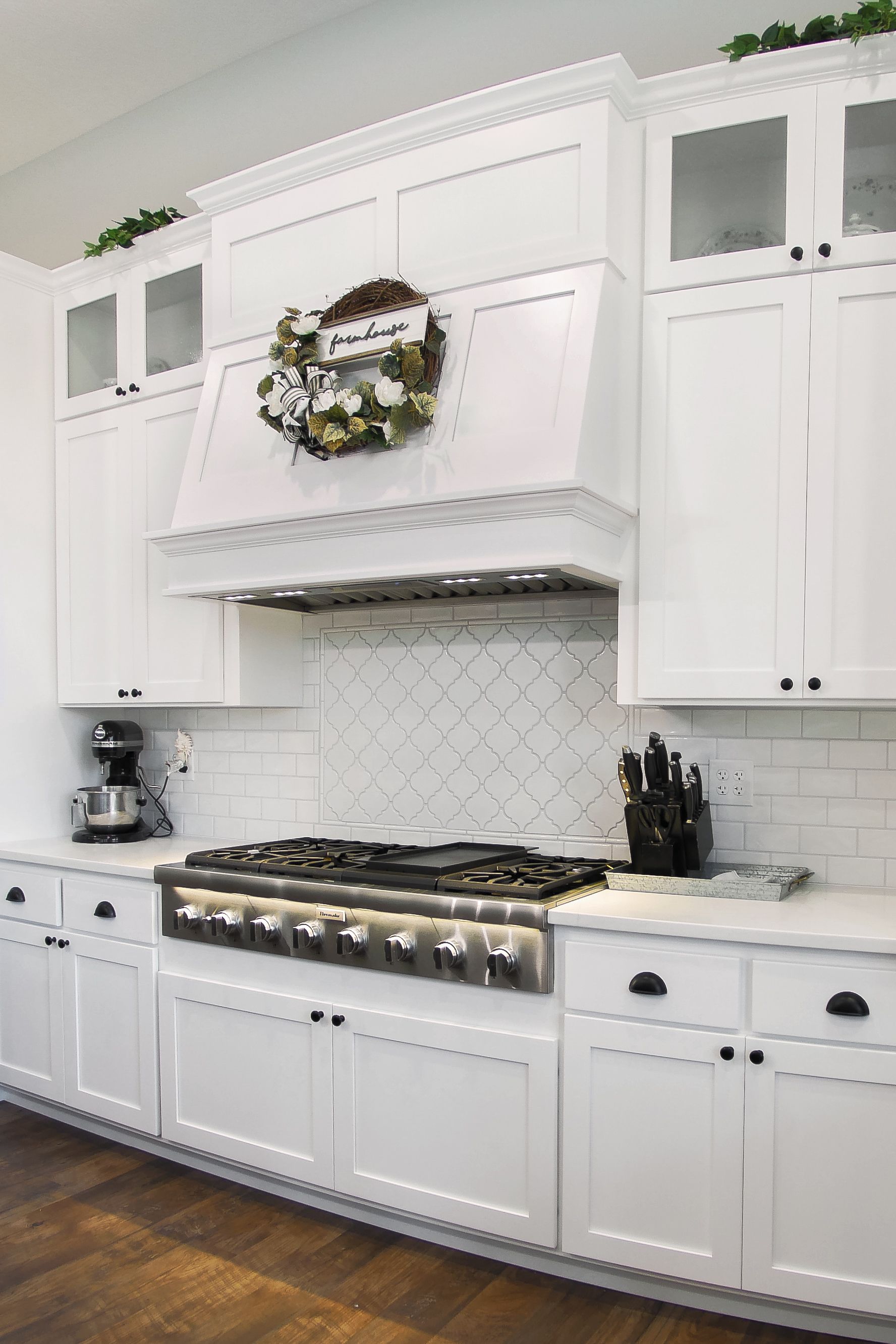 Custom white painted wood range hood and high end range.